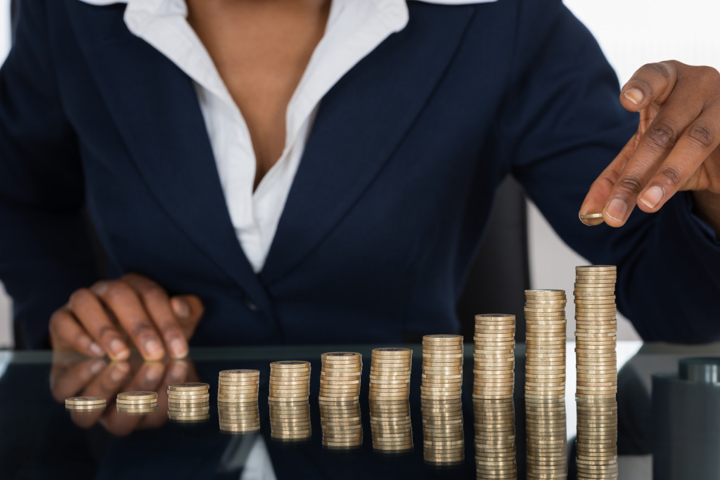 Close-up Of A Businesswoman Making Stack Of Coins